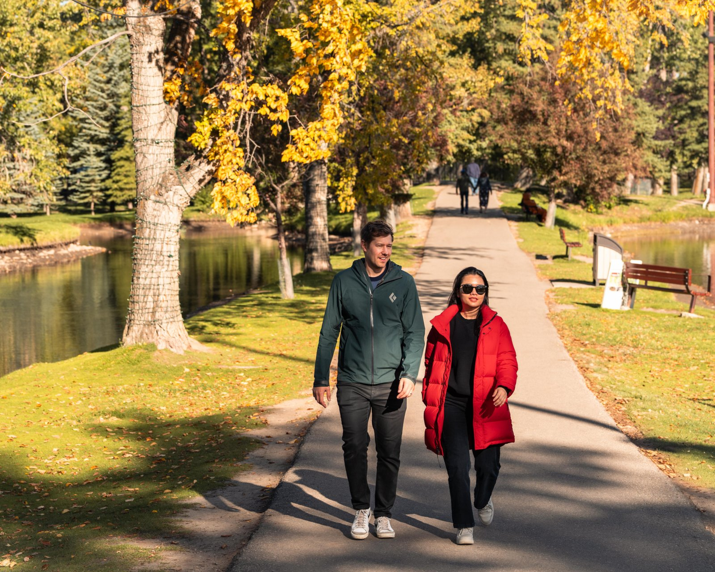 Two people walking at Bowness Park.