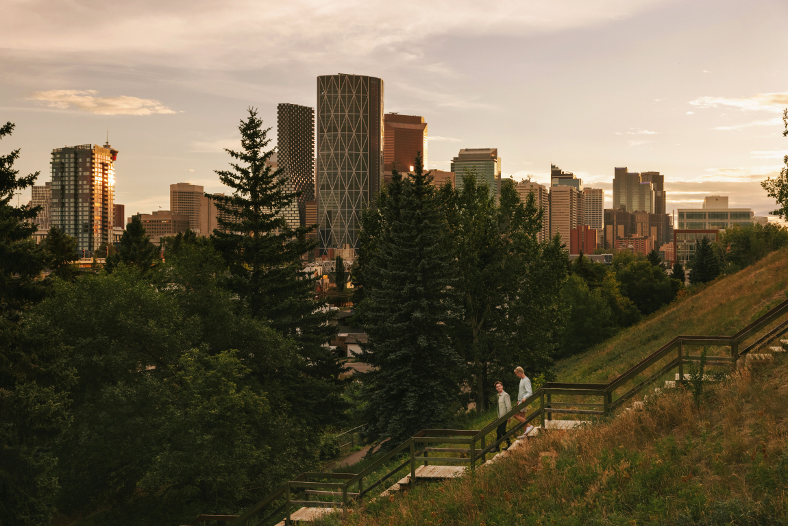 Couple walking down stairs in Bridgeland with the Calgary skyline in the background