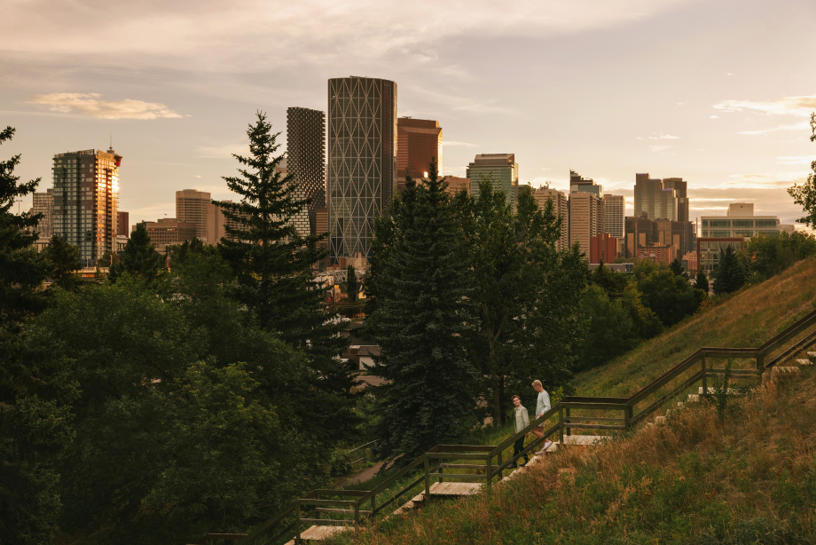 Couple walking down stairs in Bridgeland with the Calgary skyline in the background