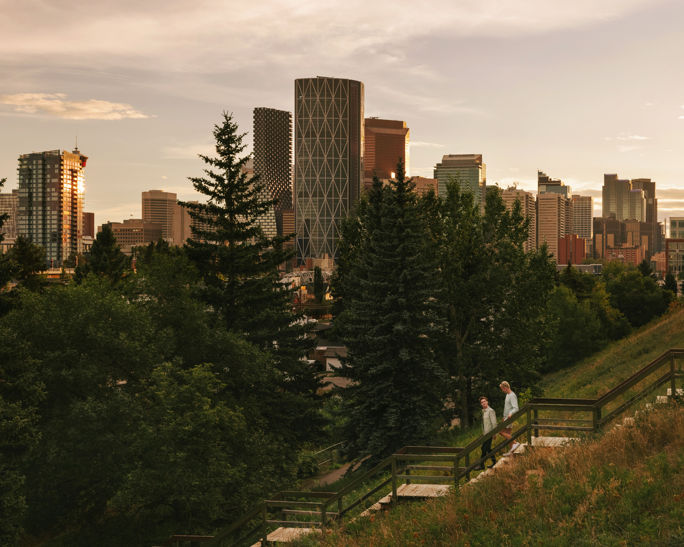 Couple walking down stairs in Bridgeland with the Calgary skyline in the background