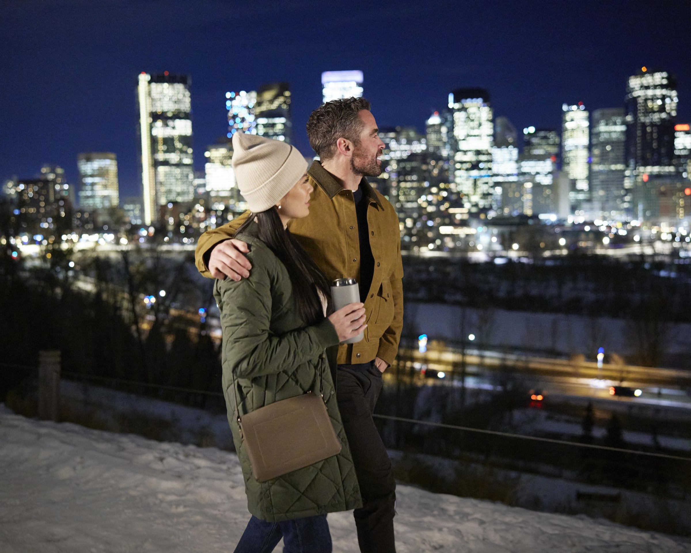 couple walking along Crescent Road admiring the skyline at night during winter