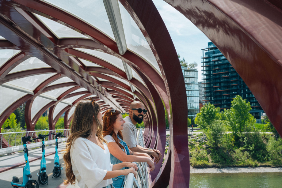friends leaning over and looking over the Peace Bridge
