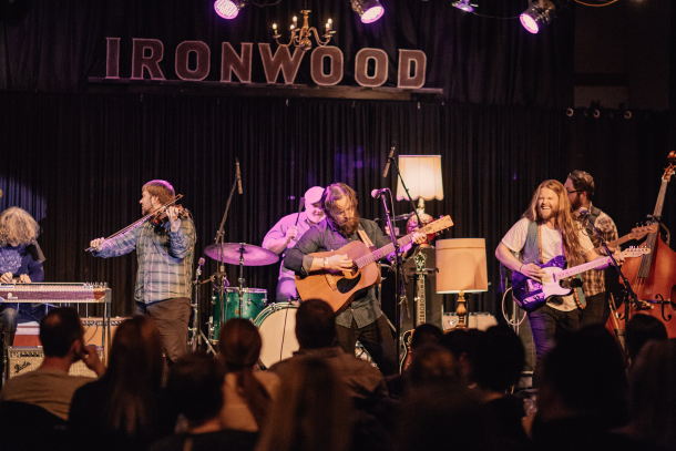 Band on stage with fans in the foreground underneath sign reading 'Ironwood'