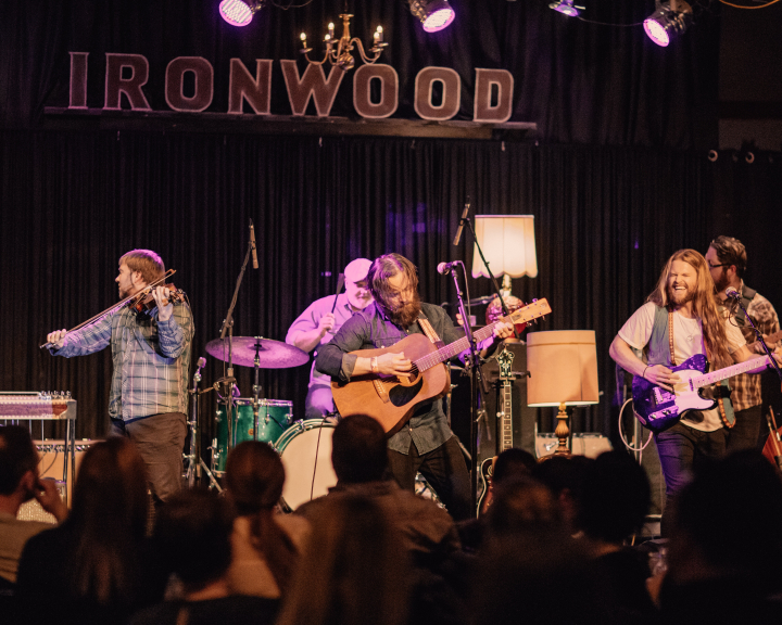 Band on stage with fans in the foreground underneath sign reading 'Ironwood'