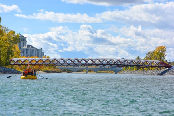 People rafting down the Bow with the city skyline in the background.