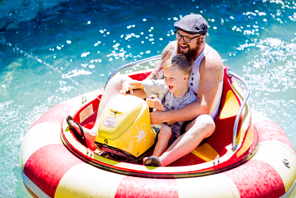 Father and son having fun on bumper boat ride