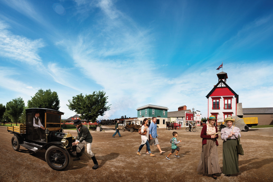 Family walking by historical actors under a blue sky at Heritage Park in Calgary