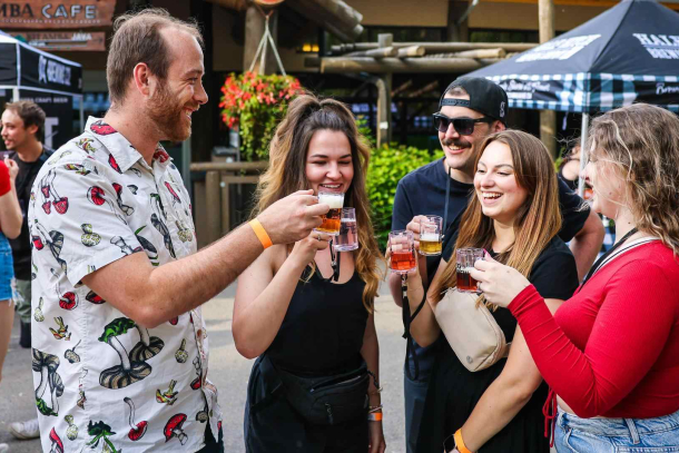 Group of adults standing and having a drink together at Wild After Hours