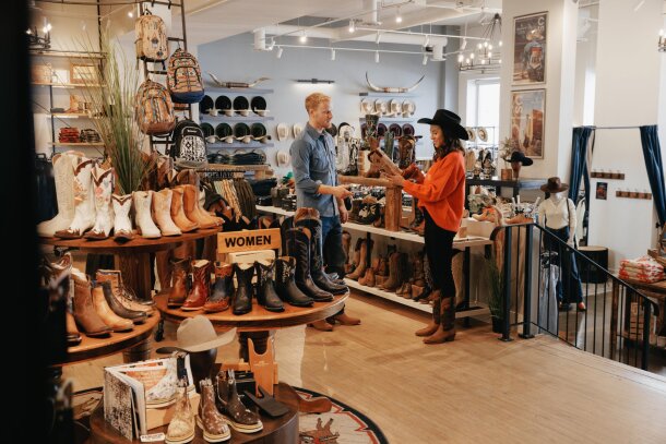 A man and a woman shopping for boots at Alberta Boot Co.