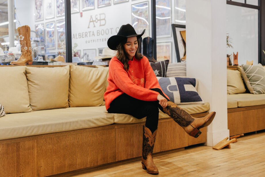 Woman trying on boots at Alberta Boot Co, Calgary