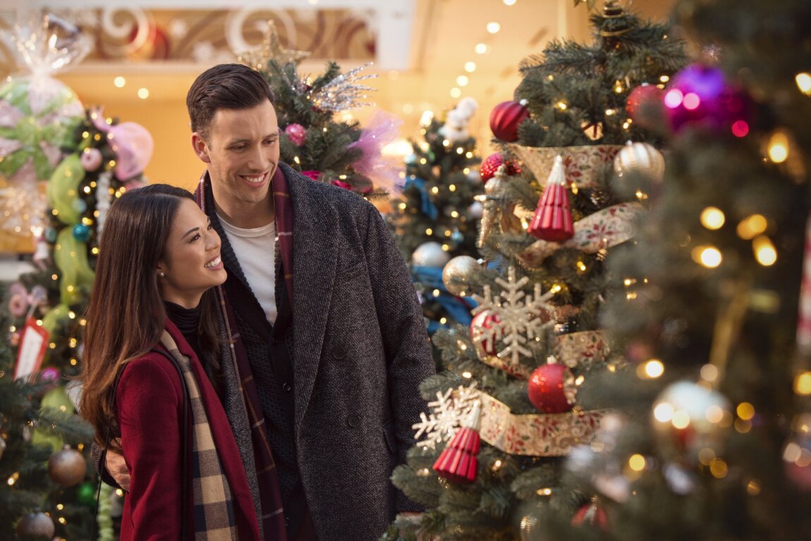 Couple standing and looking at a Christmas tree
