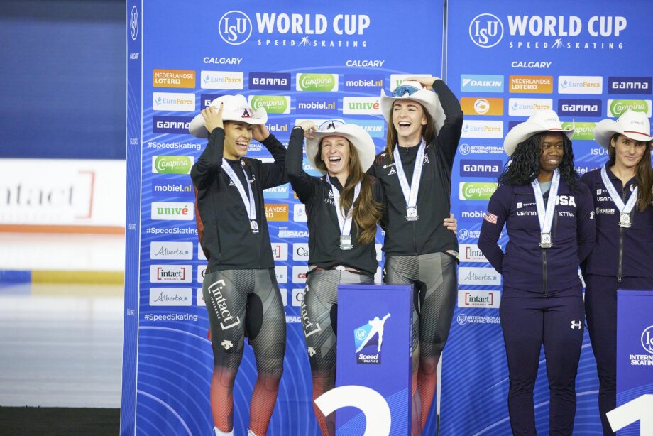 Speed skating team accepting medals at the podium