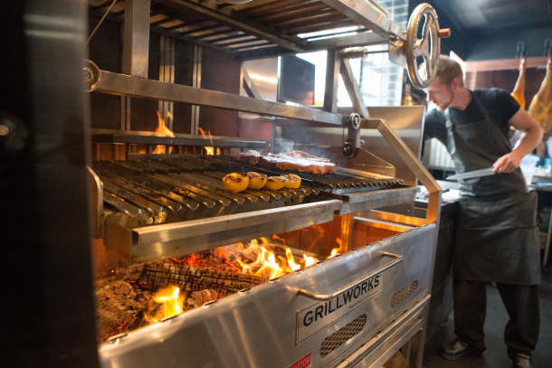 Chef working near the grill in the kitchen at Charbar Restaurant in Calgary