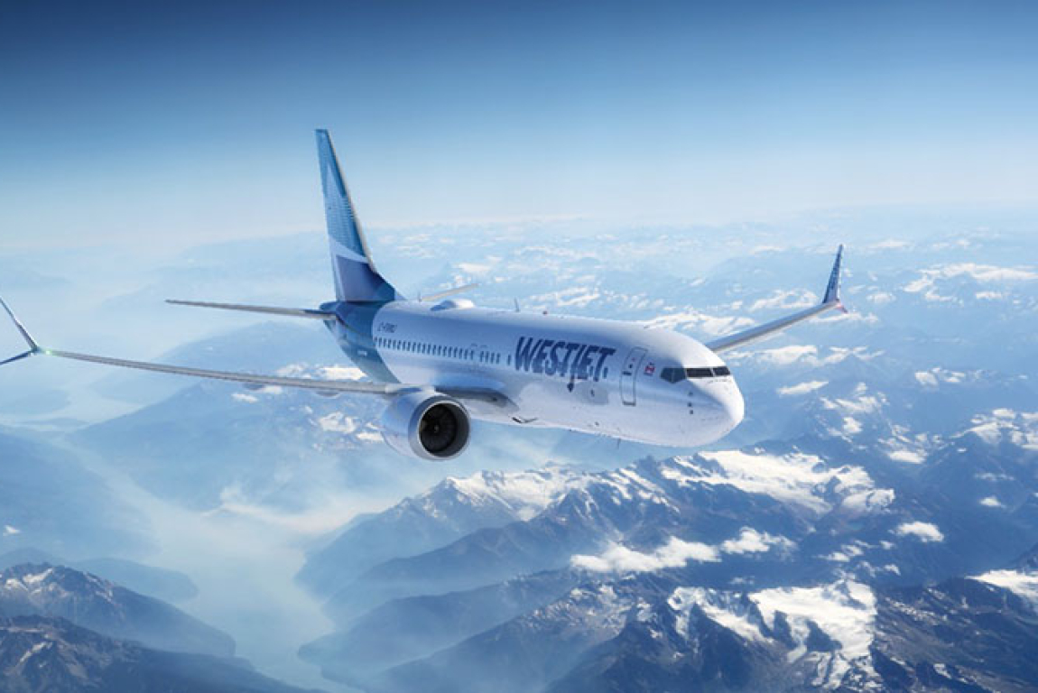 WestJet plane flying over the Canadian Rockies