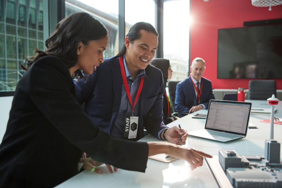 Man and woman having a meeting, pointing to a 3d model of Calgary